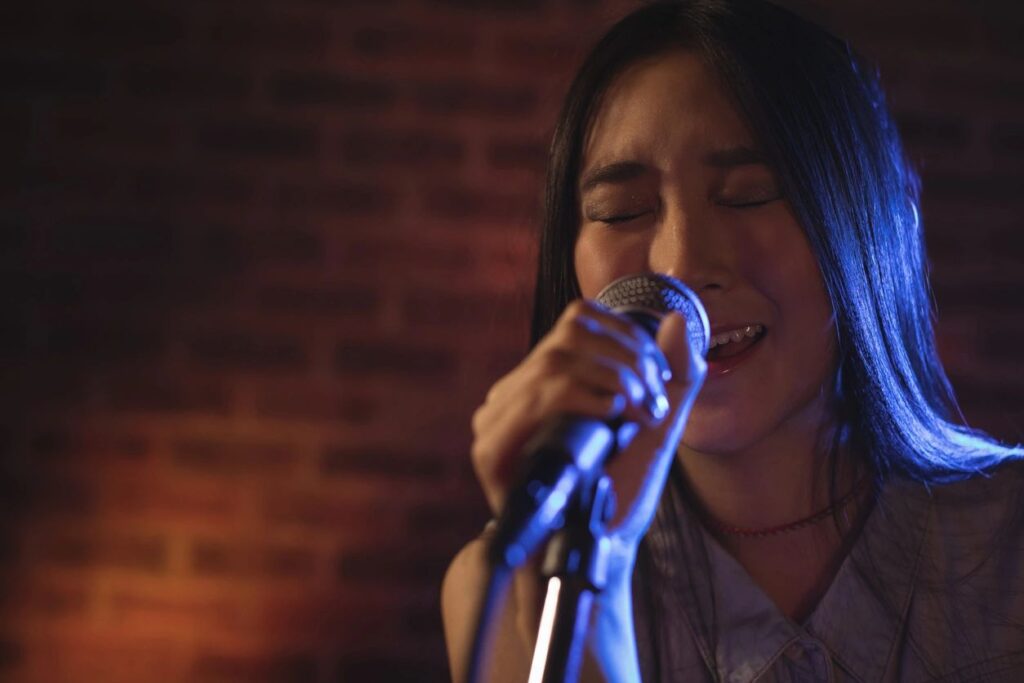 A woman passionately singing into a microphone.